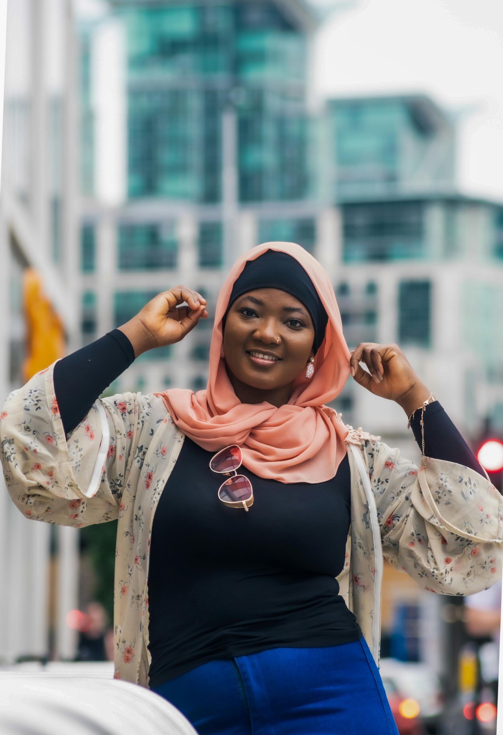 Confident African American woman in a hijab smiling outdoors in London street scene.